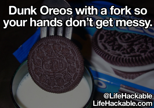 Image: Someone using a fork to dip an Oreo biscuit in a glass of milk. Image text: Dunk Oreos with a fork so your hands don't get messy.